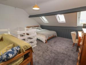 a bedroom with two beds and a desk and chairs at Badgers in Sedbergh