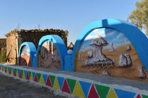 un mural en una pared con una pintura. en safari desert en Bawiti