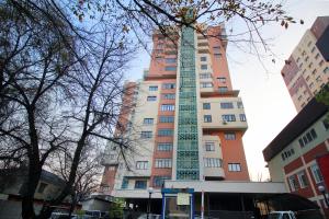 a tall building with a green tower on it at Modern, Spacious and Elegant Apt in Almaty