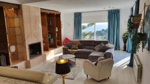 a living room with a couch and a fireplace at Opening Doors Premiá Dalt Amazing views w pool in Premia de Dalt