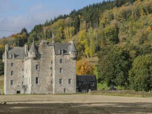 an old castle in the middle of a field at Osprey View Lodge & Hot Tub in Aberfeldy