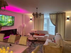 un soggiorno con luci rosa sul soffitto di Villa Segny a Ségny