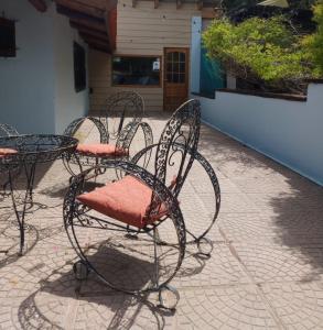 un grupo de sillas con asientos rojos en un patio en Cuatro Cerros Hostel en San Carlos de Bariloche