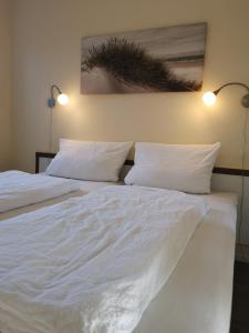 Duas camas num quarto com lençóis e almofadas brancos em Ostseebrise 9211 - Fehmarn em Fehmarn