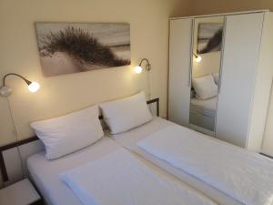 um pequeno quarto com uma cama com duas almofadas em Ostseebrise 9211 - Fehmarn em Fehmarn