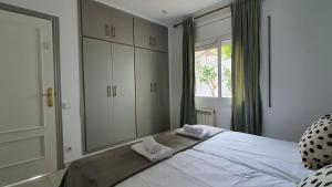 1 dormitorio con 1 cama grande y toallas. en Opening Doors Premiá Dalt Amazing views w pool, en Premià de Dalt