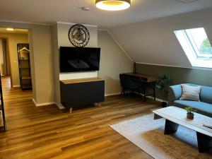 sala de estar con sofá y TV en Suite 4 SZ-Lichtenberg, en Salzgitter