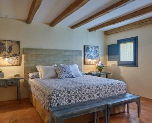 a bedroom with a bed and a bench in it at Els Masos de Caula in Girona