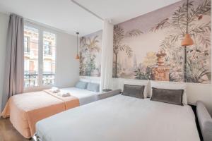 ein Schlafzimmer mit 2 Betten und einem Wandgemälde in der Unterkunft Résidence Le Belleville in Paris