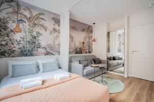 a bedroom with a bed and a painting on the wall at Résidence Le Belleville in Paris