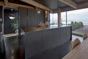 a kitchen with gray cabinets and a large window at Edge House in Aberporth