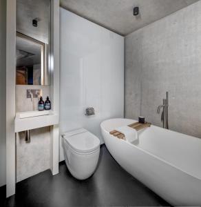 a bathroom with a tub and a toilet and a sink at Edge House in Aberporth