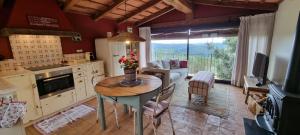 a kitchen and living room with a table and a couch at Els Masos de Caula in Girona