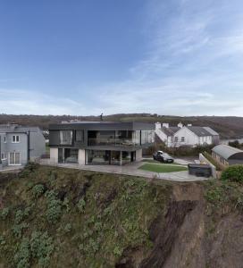a house on a hill with a car parked in front at Edge House in Aberporth