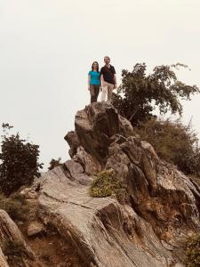 a man and woman standing on top of a rock at Deogarh Hills A Village Experience Property in Kaunthal