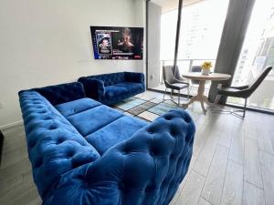 迈阿密Amazing apt with ocean view heart Miami free pool的客厅里有一张蓝色的沙发和一张桌子