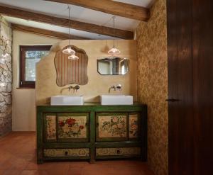 uma casa de banho com dois lavatórios e dois espelhos em Els Masos de Caula em Girona