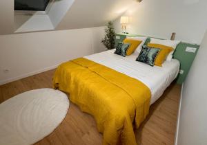 um quarto com uma cama grande e um cobertor amarelo em Au Duplex d'Or Centre Historique em Besançon