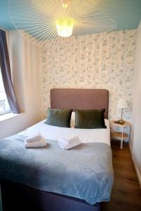 una camera da letto con un letto e due asciugamani di La Company Des Concierges : La Bonbonnière a Caen