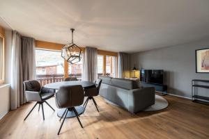 ein Wohnzimmer mit einem Tisch und einem Sofa in der Unterkunft Mera Peak Prime Apartment in Zermatt