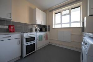 Stunning apartment in Dulwich في لندن: مطبخ مع أجهزة بيضاء ونافذة