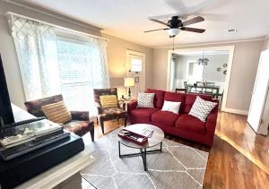 a living room with a red couch and chairs at KING BED Family Friendly Cottage - Walk to Zoo & Waterpark - Near Downtown & Midtown in Hattiesburg