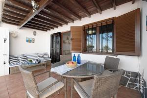 a dining room with a glass table and chairs at Puerto Chico A in Playa Blanca
