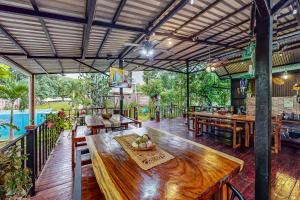a restaurant with a wooden table and a pool at Nueva Villa Paraíso Four Villas in Lagunillas
