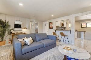 sala de estar con sofá azul y cocina en Brookside Mountain Modern Apartment / MTN views!, en Colorado Springs