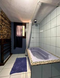 uma casa de banho com uma banheira com um tapete roxo em Casa Espaciosa em Quetzaltenango