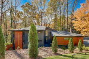 una casa en el bosque con árboles en Mid-Century Modern Luxe Retreat with Hot Tub and Decks, en Atlanta