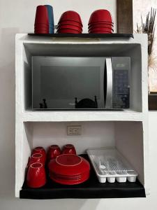 a microwave oven with red bowls and plates in it at Casa Espaciosa in Quetzaltenango