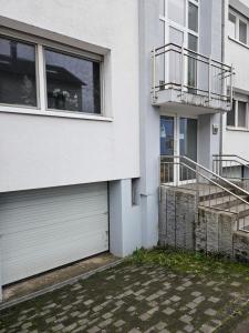 - un bâtiment blanc avec une porte de garage et un balcon dans l'établissement Ferienwohnung Saika, à Diefflen