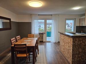 Il comprend une cuisine et une salle à manger avec une table et des chaises en bois. dans l'établissement Ferienwohnung Saika, à Diefflen