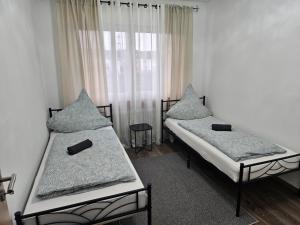 - 2 lits jumeaux dans une chambre avec fenêtre dans l'établissement Ferienwohnung Saika, à Diefflen