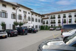 ein Parkplatz mit Autos vor den Gebäuden in der Unterkunft Sabotin, Hotel & Restaurant in Nova Gorica