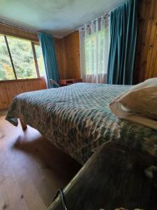 a bedroom with a bed in a room with windows at Nómada Austral in Puerto Montt