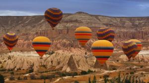 un groupe de montgolfières survolant un canyon dans l'établissement ADA FAMILY SUITE, à Avanos