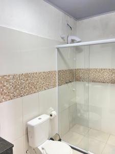 a bathroom with a toilet and a glass shower at Pousada Villa Sambaqui in Penha