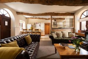 a living room with a leather couch and a table at The Stables in Tunstead