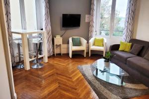 a living room with a couch and chairs and a tv at Le lumineux - Appartement central sur parquet chevrons - Chez Lulu in Nantes
