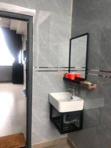 baño con lavabo y espejo en la pared en Nhà Nghỉ A&Em, en Xã Bình Hòa