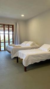 2 Betten in einem Zimmer mit Fenster in der Unterkunft Casa B&B in Jijoca de Jericoacoara