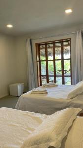 a bedroom with two beds and a window at Casa B&B in Jijoca de Jericoacoara