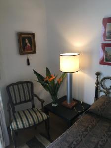 ein Schlafzimmer mit einer Lampe und einem Stuhl neben einem Bett in der Unterkunft MARIA ROSARIA A SANTA CHIARA in Neapel