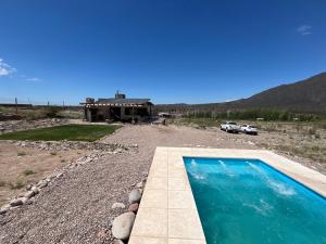 a house with a swimming pool in front of a house at Wabi sabi, casita de montaña con pileta in Mendoza