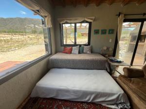 two beds in a room with a window at Wabi sabi, casita de montaña con pileta in Mendoza