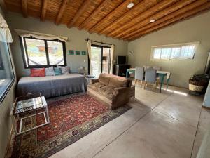 a bedroom with a bed and a couch and a table at Wabi sabi, casita de montaña con pileta in Mendoza