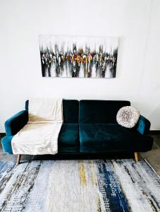 a black couch in a living room with a painting at La Villa Louisia in Matoury