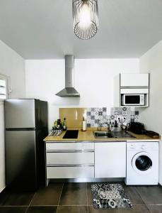 a kitchen with a refrigerator and a sink at La Villa Louisia in Matoury